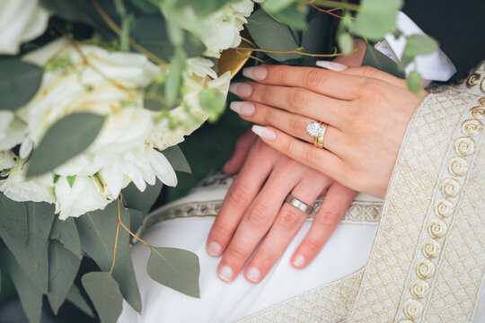 Close Up of Bride and Groom Holding Hands with Wedding Rings and White Flowers &ndash; Muslim Wedding, Marriage Ceremony, Love, Romance, Commitment, Engagement, Bridal Jewelry, Islamic Culture, Marriage