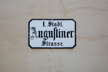 A sign with the name of the Augustinerstrasse street in Gothic script in the center of Vienna
