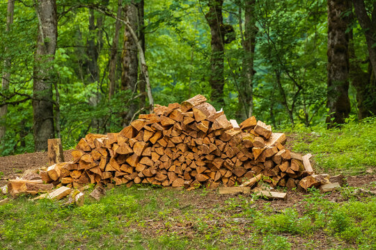 A pile of stacked firewood, prepared for heating the house, Chopped firewood on a stack. Pile of firewood loggs.