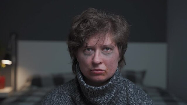 Offended and desperate woman with injuries on face and knocked out tooth at home looks at camera, screaming stop and crying. Stop domestic violence concept. Female hand stops male fist from being hit.