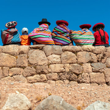 Peruvian indigenous quechua people on inca wall, Cusco province, Peru.