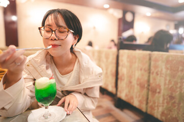 Asian woman drinking icecream melon soda menu relax in kissaten japan style retro coffee shop