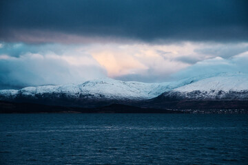 Waterscape with snow-covered mountains on the fjord shore near Tromso, Norway
