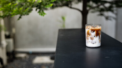 Iced coffee with milk in a glass on a table in a cafe