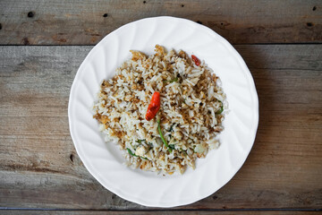 Fried rice with eggs in a plate placed on a wooden table
