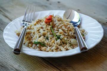 Fried rice with eggs in a plate placed on a wooden table