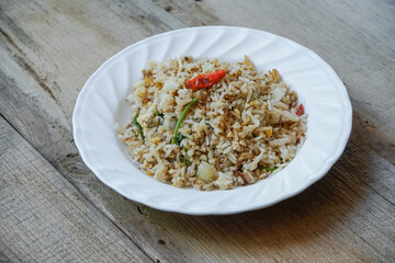 Fried rice with eggs in a plate placed on a wooden table