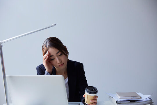 職場のデスクでパソコンを見て暗い表情をする女性