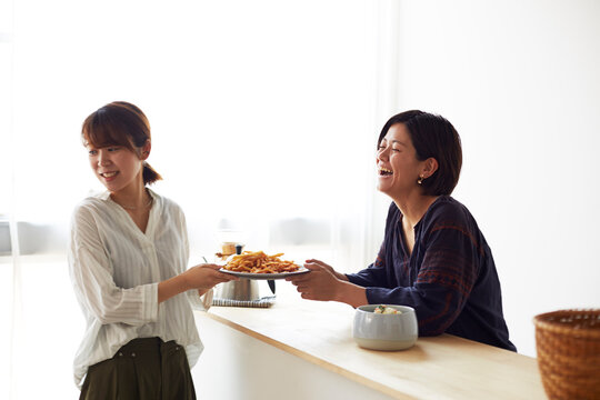 料理が盛られたお皿を受け渡しする2人の女性