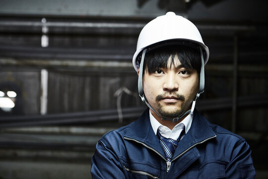 正面を向く作業服とヘルメットの男性