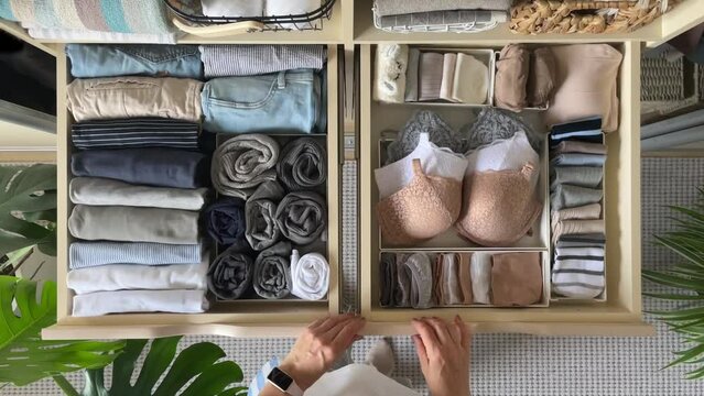 An unidentified neat housewife takes underwear, socks, panties and a bra from a closet drawer. The concept of organization, storage and order. 