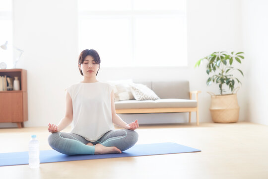 室内で床でヨガのポーズをする女性