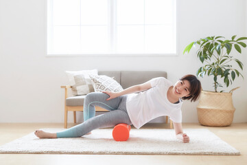室内の床でストレッチポールを使ってストレッスル女性