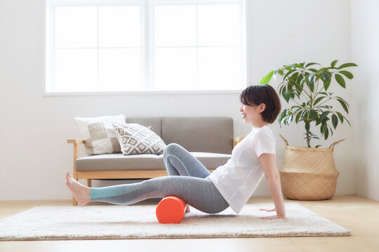 室内の床でストレッチポールを使ってストレッスル女性