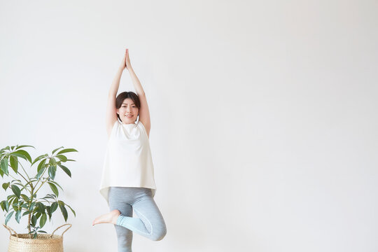 室内でヨガのポーズをとる女性