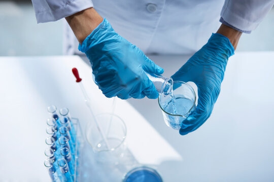 白い空間で実験をしている白衣を着た男性