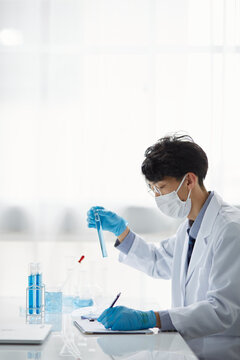 白い空間で実験をしている白衣を着た男性