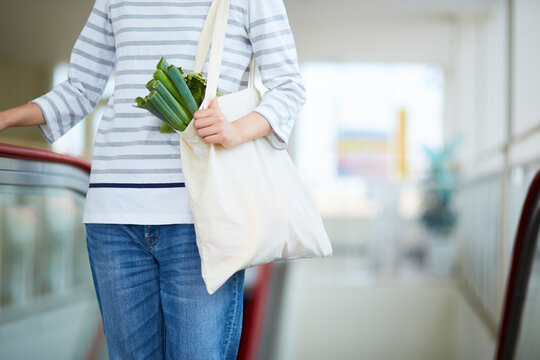 エコバッグに入れた食材を運んでいる女性