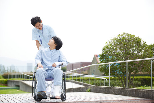 散歩する車椅子の患者と看護師