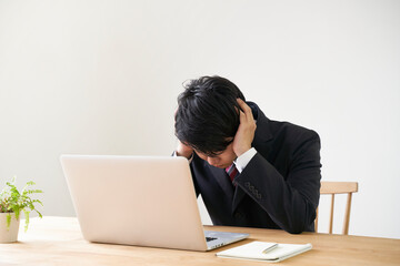 パソコンでのオンライン面接で頭を抱える男子の就活生