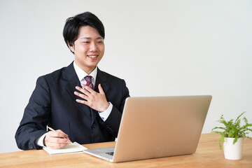 パソコンでオンライン面接をする男子の就活生