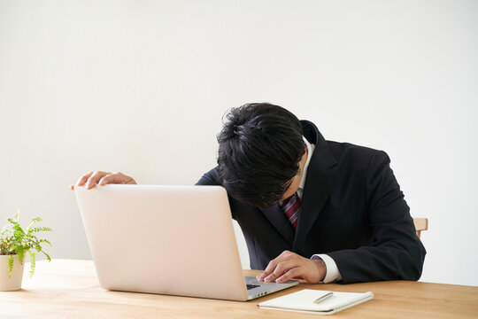 パソコンでのオンライン面接で頭を下げる男子の就活生