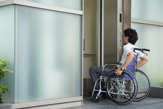 エレベーターに乗ろうとする車椅子の男性