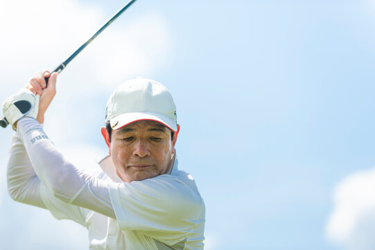 ゴルフをする中高年男性
