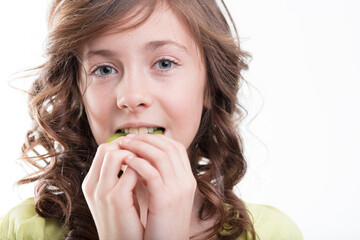 Blue-eyed, brown-haired girl enjoys tasty kiwi