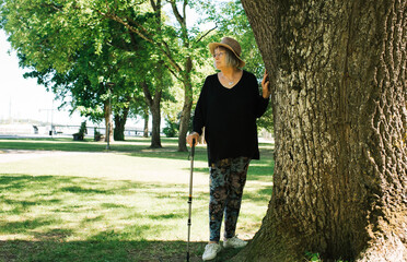 pensioner taking a break from walking with a stick outside