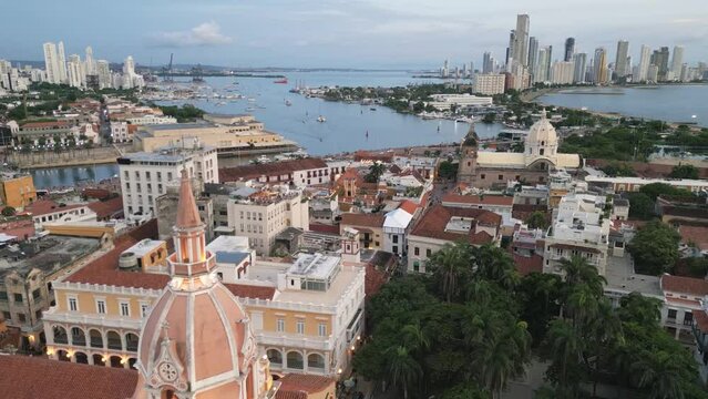 aerial pano of Cartagena de Indias old town wall with cathedral cusp and modern skyscraper building drone cityscape Caribbean coast with port