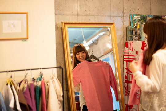 雑貨屋さんで服を選んでいる女性