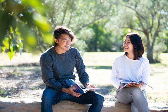 緑の中で座って話している男女二人