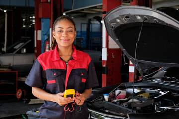 One Black female professional automotive mechanical worker checks an EV car battery and hybrid...