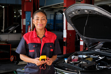 One Black female professional automotive mechanical worker checks an EV car battery and hybrid engine at a maintenance garage, expert electric vehicle service, and fixing occupations auto industry.