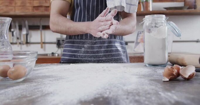Midsection of caucasian man preparing bread dough in kitchen, copy space, slow motion