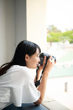 一眼レフカメラで写真を撮影している女性