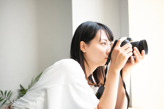 一眼レフカメラで写真を撮影している女性