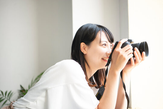 一眼レフカメラで写真を撮影している女性