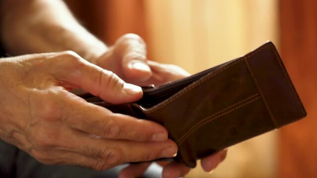 Hands of an elderly man holding an empty wallet