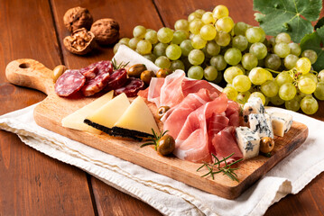 Selezione di salumi, formaggi e frutta, antipasti misti di terra italiani, cibo europeo 