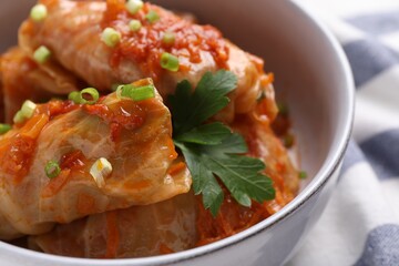 Delicious stuffed cabbage rolls cooked with homemade tomato sauce in bowl, closeup