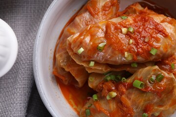 Delicious stuffed cabbage rolls cooked with tomato sauce on table, top view