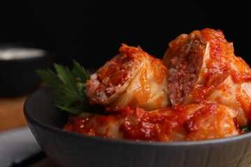 Delicious stuffed cabbage rolls cooked with homemade tomato sauce in bowl, closeup