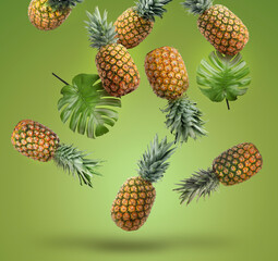 Fresh pineapples and monstera leaves falling on green background