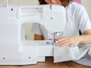 Fashion, fabric and sewing, woman at machine in small business with creative ideas and focus at home studio. Creativity, startup and design, tailor or designer stitching, young entrepreneur at work.