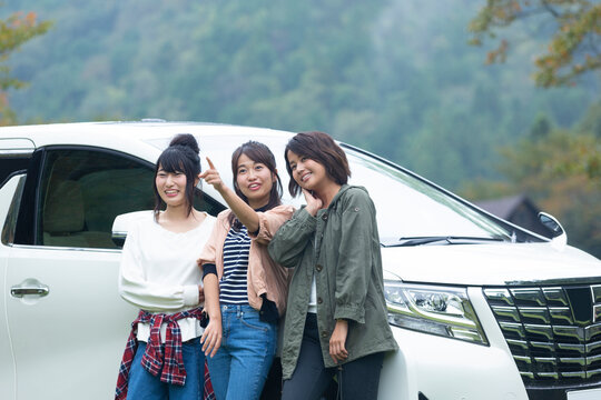 車の横に立って談笑する女性