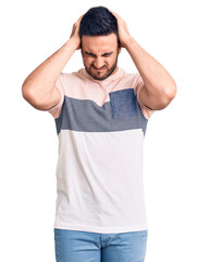 Young handsome man wearing casual clothes suffering from headache desperate and stressed because pain and migraine. hands on head.