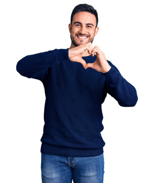 Young handsome man wearing casual clothes smiling in love doing heart symbol shape with hands. romantic concept.