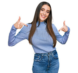 Young beautiful woman wearing casual winter sweater looking confident with smile on face, pointing...